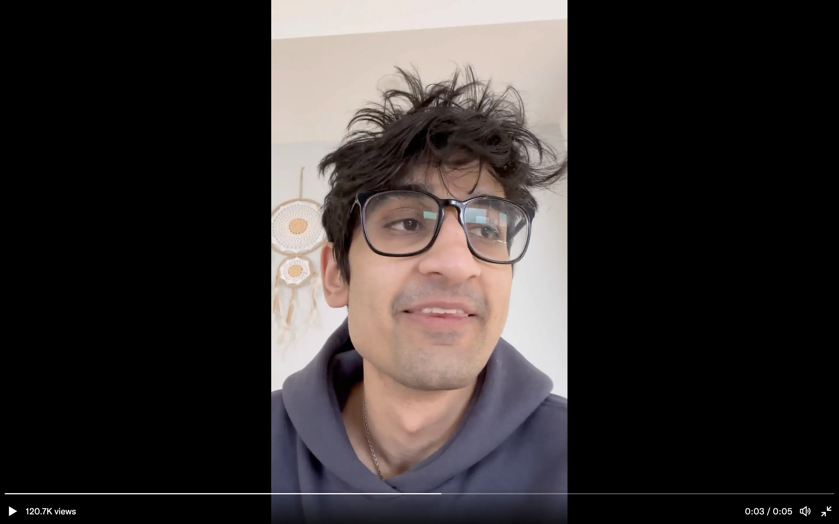 A man with messy hair, glasses, and a grey sweatshirt speaks to the camera. It is Frank DeGods Doxxing himself.